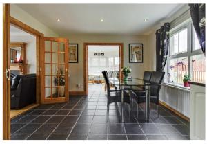 a dining room with a table and black chairs at Muff 4 bed holiday rental in Muff