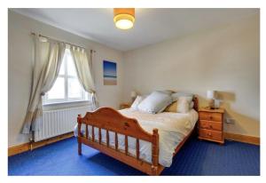 a bedroom with a wooden bed and a window at Muff 4 bed holiday rental in Muff