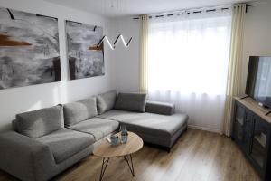 a living room with a couch and a tv at Apartament Komfort in Słupsk