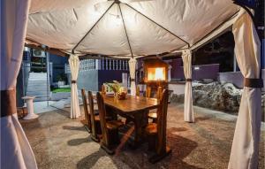 a tent with a wooden table and chairs at Amazing Home In Srinjine With Jacuzzi in Srinjine