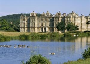 a group of ducks swimming in a lake in front of a castle at Tucking Mill View- Self Catering in Bath