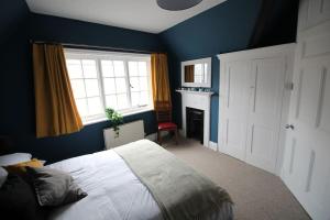 a blue bedroom with a bed and a window at Pier View 2 Bedroom Apartment in Cowes