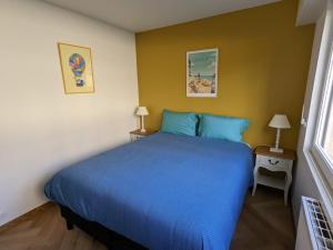 a bedroom with a blue bed in a room at Les Tennis - Superbe appartement avec parking in Houlgate