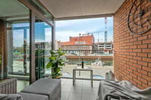 a balcony with a view of a city at Waterlane Riverside - SPA, Pool, Gym & Parking by Downtown Apartments in Gdańsk