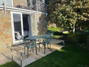 una mesa y sillas en un patio en Immaculate 1-Bed Studio with outside patio en Brighouse