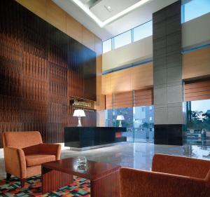 eine Lobby mit einem Stuhl und einem Tisch in einem Gebäude in der Unterkunft Luxury, Modern & Spacious Two Bedrooms Fully Furnished Apartment in Jakarta