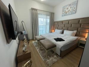 a bedroom with a large bed and a television at Private gorgeous Room with Marina view with Shared Kitchen in Dubai