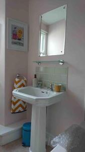 a bathroom with a white sink and a mirror at Grocer John's. The heart of the old town in Padstow