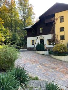 a large house with a brick driveway in front of it at Hotel Orionka in Liberec