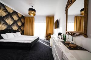 1 dormitorio con cama y espejo grande en POŁUDNIK PARK Boutique Hotel Conference&SPA en Stargard Szczeciński