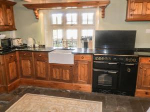 a kitchen with a black stove and a sink at Bute Cottage in Pickering