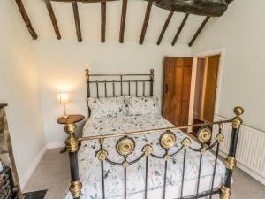 a bedroom with a metal bed in a room at Bute Cottage in Pickering