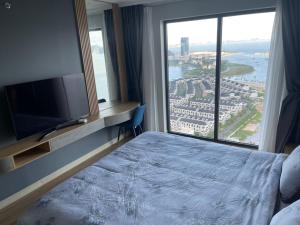 a hotel room with a bed and a large window at Citadine Ha Long luxury (Ocean View) in Ha Long