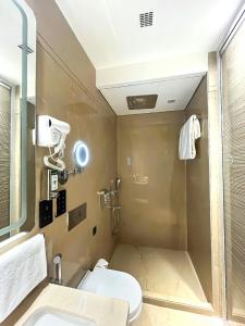 een badkamer met een douche, een toilet en een wastafel bij Morvee Hotels Alipore Kolkata in Calcutta