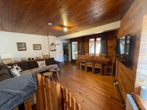 uma sala de estar com um sofá e uma sala de jantar em LE BLIZZARD Bel appartement avec grande terrasse dans vieille ferme de montagne rénovée em Les Orres