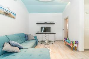 sala de estar con sofá azul y TV en Villa Sunny Home, en Galižana