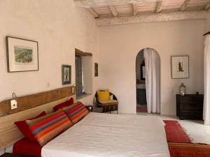 a bedroom with a bed and a chair at RIAD CHANT D'ETOILES tadighoust in El Hara