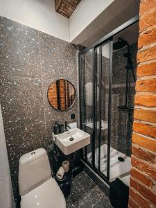 ein Badezimmer mit einem Waschbecken, einem WC und einem Spiegel in der Unterkunft 1880 Apartment with Private Parking in Marijampolė