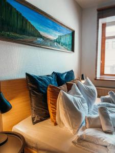 a room with a bed with pillows on it at 1880 Apartment with Private Parking in Marijampolė