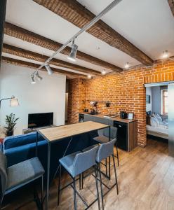 a kitchen with a brick wall and a table and chairs at 1880 Apartment with Private Parking in Marijampolė