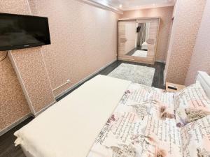 Habitación pequeña con cama y TV de pantalla plana. en Testemiteanu apartment, free wifi available, en Chişinău