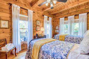 2 camas en un dormitorio con paredes y ventanas de madera en Carolina Mountain Retreat, en Shumont