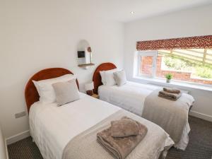 two beds in a room with a window at Foulsyke Farm Bungalow in Saltburn-by-the-Sea