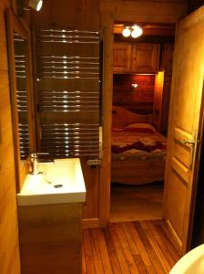 ein Bad mit einem Waschbecken und ein Bett in einem Zimmer in der Unterkunft Chalet Narcisse in Sixt