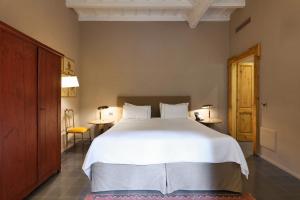 a bedroom with a large white bed and two tables at Maison Borella in Milan