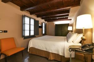 a bedroom with a bed and a desk and a phone at Maison Borella in Milan