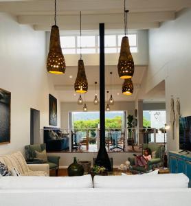 a living room with several lights hanging from the ceiling at Mes Amis Beach Guest House in Wilderness