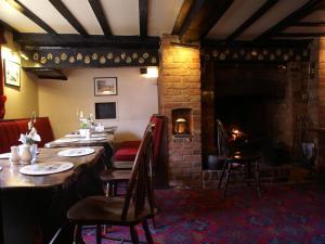a dining room with a table and a fireplace at THE SARACENS HEAD INN in Amersham