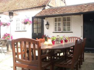 a wooden table and chairs in front of a house at THE SARACENS HEAD INN in Amersham