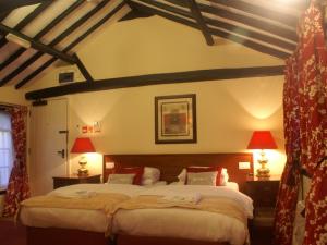 a bedroom with two beds and two lamps at THE SARACENS HEAD INN in Amersham