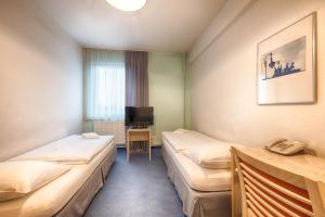 a hotel room with two beds and a television at enjoy hostel Berlin City West in Berlin