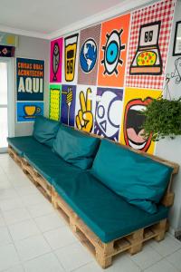 um sofá verde em frente a uma parede com graffiti em Casa Ecotrips Barra Funda - Hostel em São Paulo