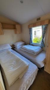 2 camas en una habitación pequeña con ventana en 19 Barnacre Scorton Six Arches caravan park, en Scorton