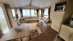 una sala de estar con sofá y mesa en una caravana en 19 Barnacre Scorton Six Arches caravan park, en Scorton