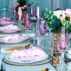 una mesa con platos, copas de vino y servilletas rosas en Luqa BnB, en Empangeni