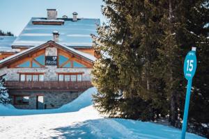 a sign in front of a house in the snow at Hotel Allodis in Méribel