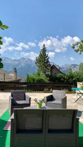 a patio with chairs and a table with a view of mountains at Chalet Martine in LʼHuez