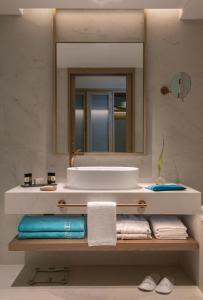 a bathroom with a sink and a mirror and towels at Mitsis Summer Palace in Kardamaina