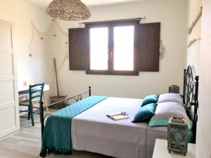 a bedroom with a bed with blue pillows at Oasi delle Onde in Villasimius