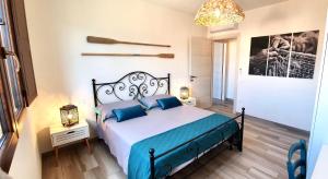 a bedroom with a large bed with blue pillows at Oasi delle Onde in Villasimius