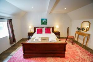 una camera da letto con un grande letto con cuscini rossi di Number Five in Earl Soham Suffolk 