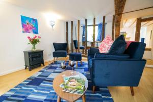 uma sala de estar com duas cadeiras azuis e uma mesa em Number Five in Earl Soham Suffolk 
