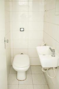 a white bathroom with a toilet and a sink at Casa Ecotrips Barra Funda - Hostel in Sao Paulo