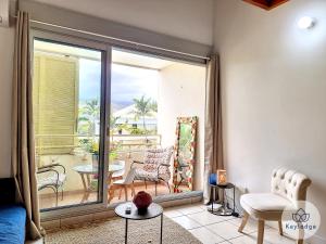 a living room with a view of a patio at Cumin - Studio duplex avec accès piscine à St-Gilles in Saint-Gilles les Bains