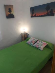 un letto verde con due cuscini sopra di Casa Cecilia ad Arrieta