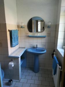 y baño con lavabo azul y espejo. en Haus Bindseil - Ferienwohnung im EG, rechts, en Altenau
